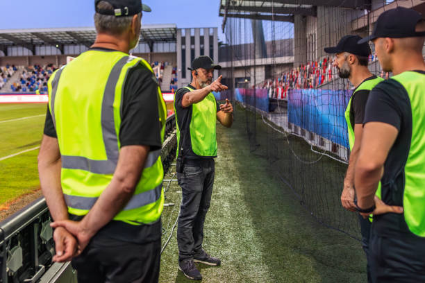 Soccer field security guards in reflective vests talking